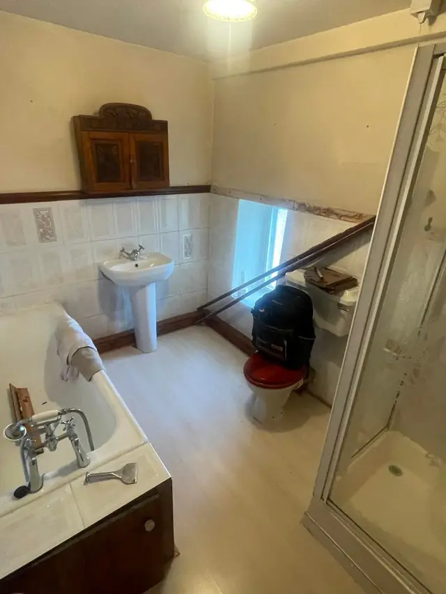 The bathroom before: a fitted bath, a separate shower cubicle, a pedestal basin and wall tiles.
