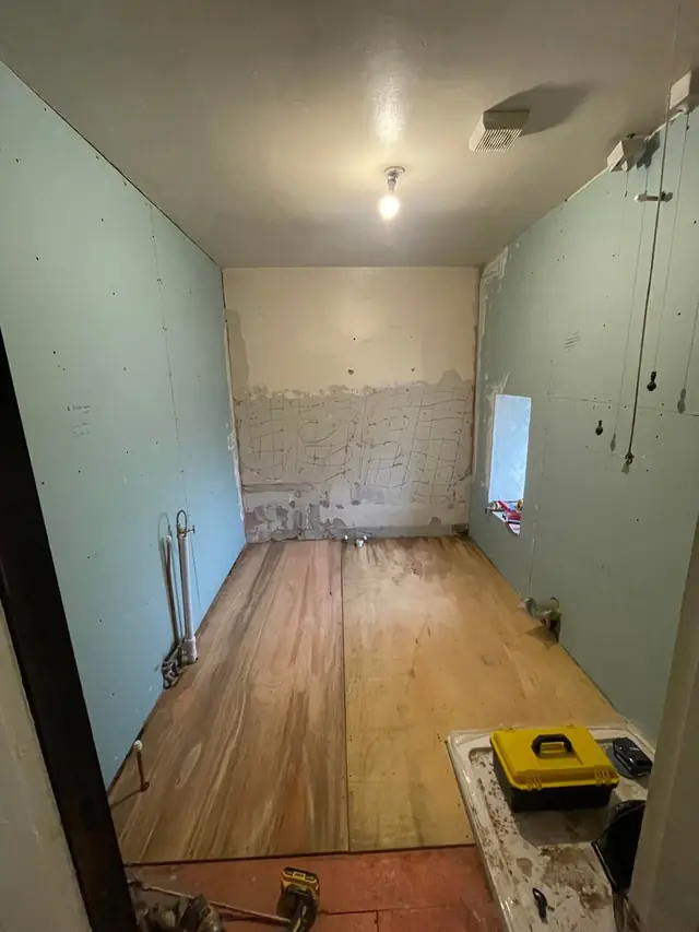 The room stripped back, with new boards on the walls and floor.