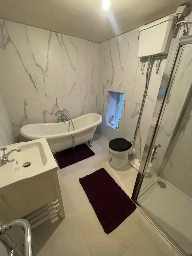 After: the roll-top bath, a vanity unit and the shower enclosure.