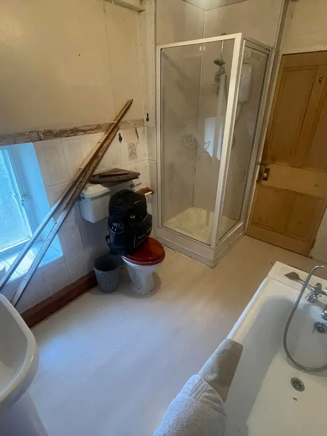 Before: the basin, shower cubicle and bath from the other end of the room.