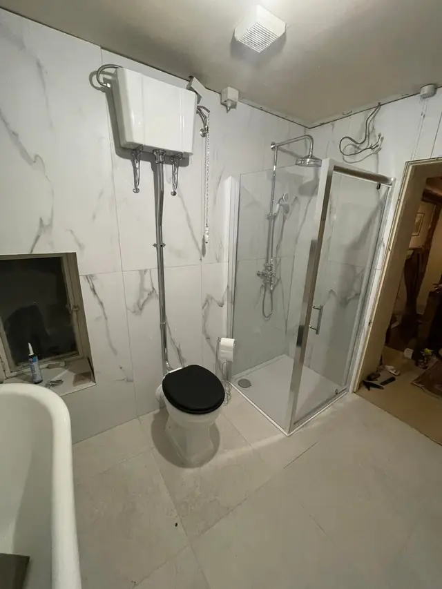 After: the high-level cistern toilet next to the shower enclosure.