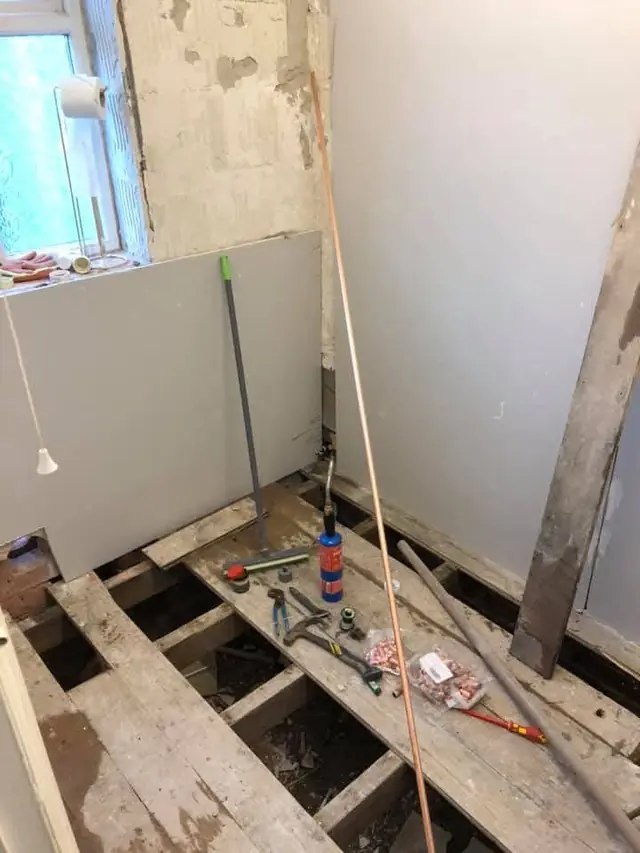 During: the floorboards up and new copper pipework run under the floor.
