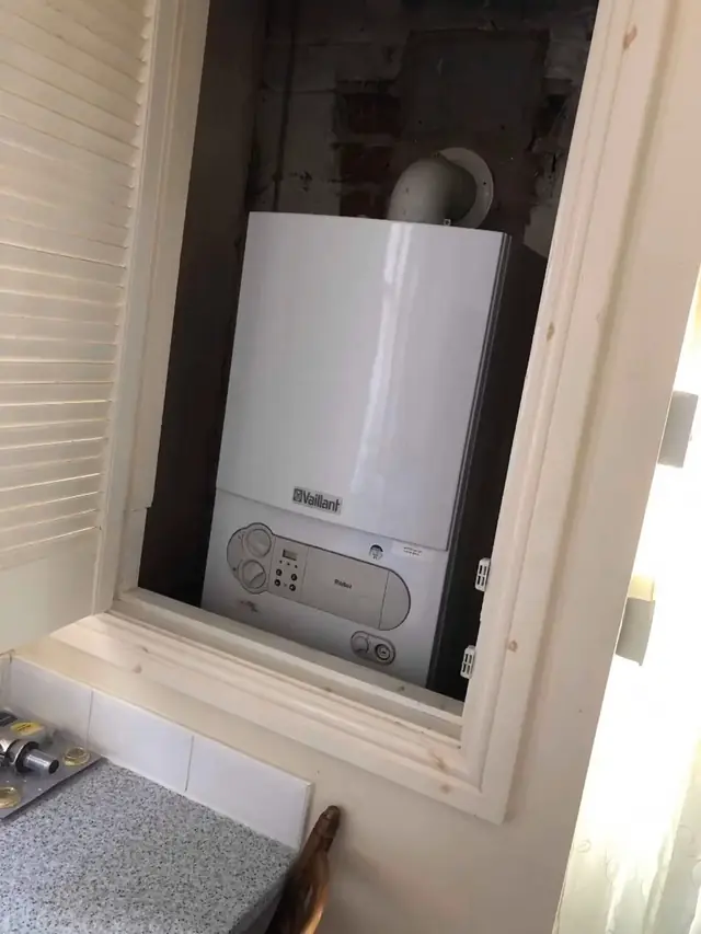 The old boiler in a kitchen cupboard, before the swap.